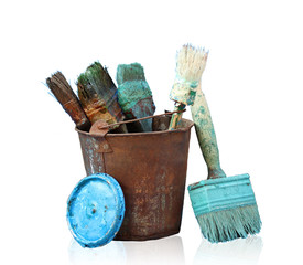 Brushes smeared in paint in an old bucket isolated on a white background