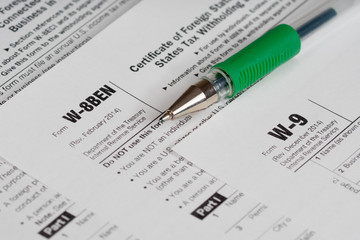 tax reporting forms with green pen