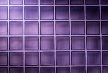 purple glass block wall background with lighting from corner