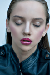 Fashion girl with pink lips posing in black leather jacket