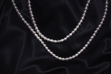 beautiful pearl necklace on a black silk