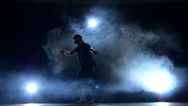 Young hiphop dancer making a move, smoke, silhouette, slow