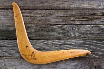 Boomerang on old wooden board - obrazy, fototapety, plakaty