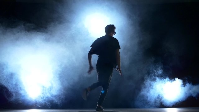 Young hiphop dancer starts making a move, smoke, silhouette