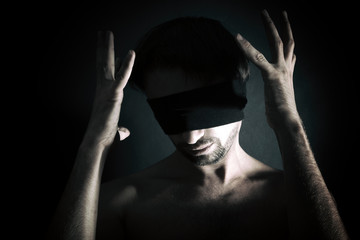 Portrait of nude blindfolded young man