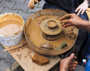 Potters wheel. potter teaches the child to his craft on a potter's wheel