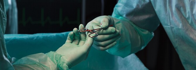Surgeons' hands holding pliers