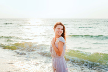 Fototapeta na wymiar young beautiful caucasian female enjoying the sun on beach during sunrise or sunset