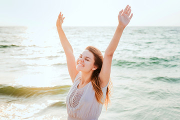 Fototapeta na wymiar young beautiful caucasian female enjoying the sun on beach during sunrise or sunset