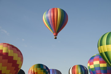 Single hot-air balloon floating above a balloon festival