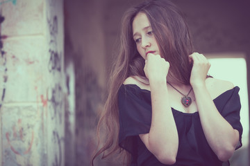 Obraz premium portrait of a beautiful young sad goth girl in an abandoned old