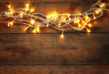 abstract photo of Christmas warm gold garland lights on wooden background