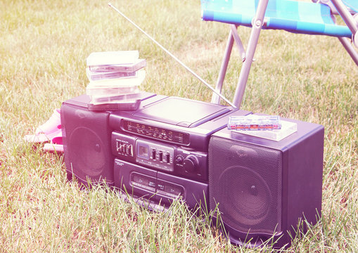 Vintage image of old tape recorder on grass in the garden