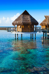 houses over the transparent quiet sea water. Tahiti