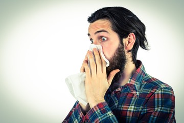 Handsome hipster blowing his nose