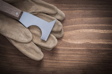 Leather protective gloves and putty spattle on wooden board