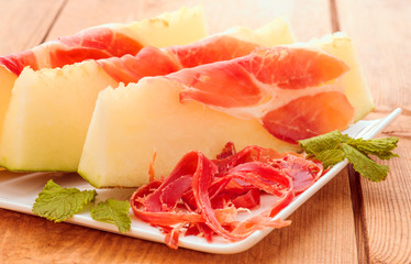 sweet melon with serrano ham cut on chips and sliced