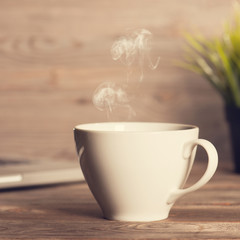 Hot coffee on wooden work desk