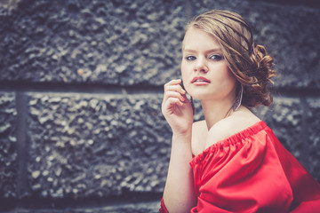 Fototapeta premium portrait of a beautiful young girl in a red dress outdoors