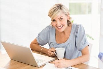 Smiling businesswoman working on a laptop