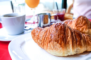 Breakfast with coffee and croissants on table