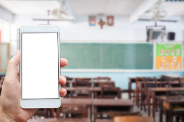 Learning conceptual- Focused on left hand holding mobile with Classroom blurred background