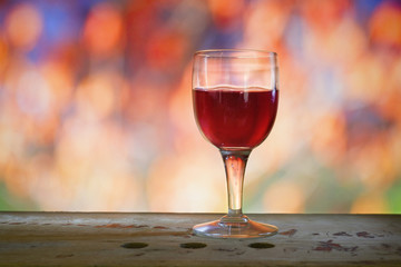 glass of wine on blurred autumn nature background, free copy space