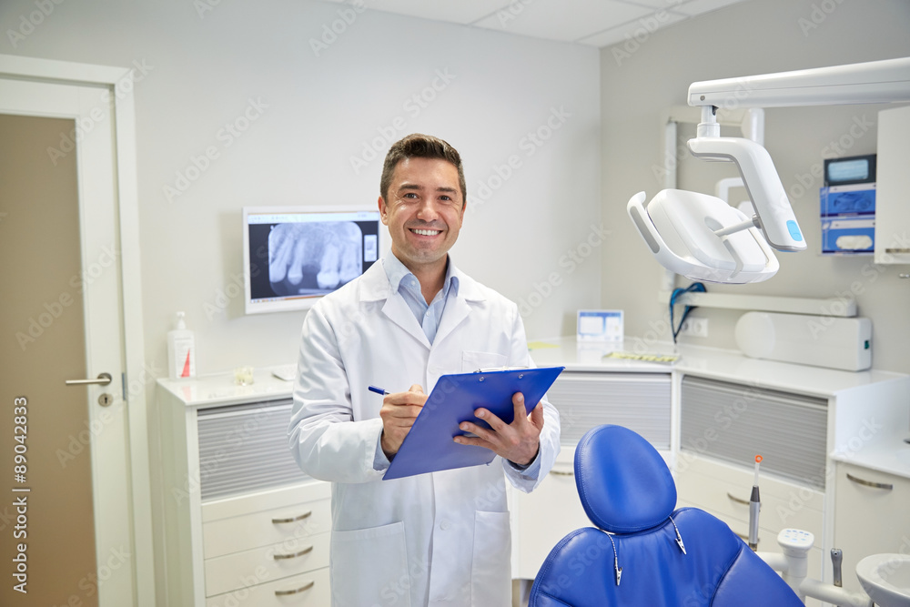 Poster happy male dentist with clipboard at dental clinic