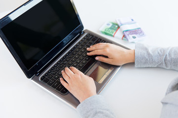 close up of woman hands with laptop and money