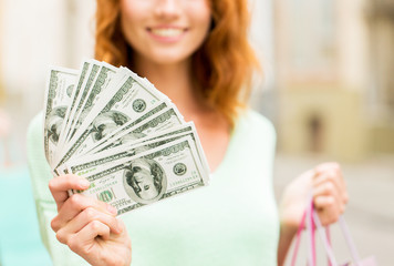 close up of woman with shopping bags and money