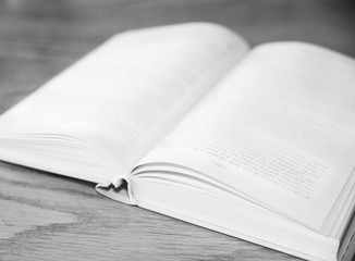 White open book on wooden table with soft focus