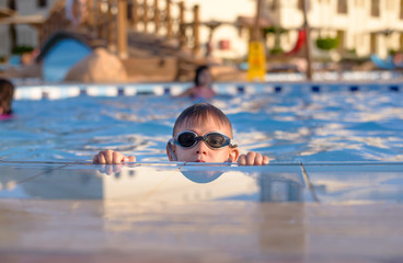 Young boy peering out of a swimming pool