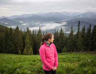 Naklejka na ściany i meble young girl in the mountains looking around in the Carpathian mountains after rain