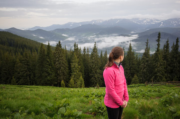 young girl in the mountains looking around