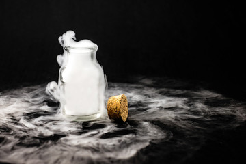 White smoke inside glass bottle at black background, Mistery hal