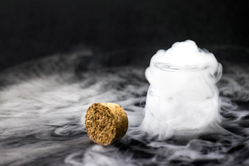 White smoke inside glass bottle at black background, Mistery hal