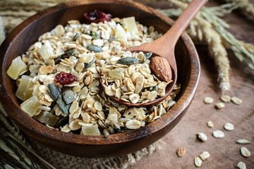 Oat and whole wheat grains flake in wooden bowl on wooden table
