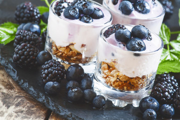 Homemade granola with yogurt, blueberry and blackberry in glass