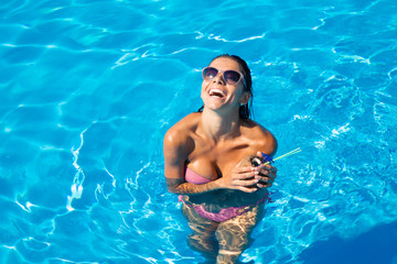 Laughing woman standing in swim pool