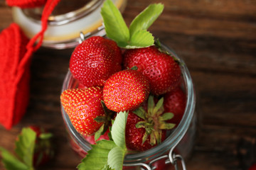 strawberries in a glass jar and an old wooden background retro vintage