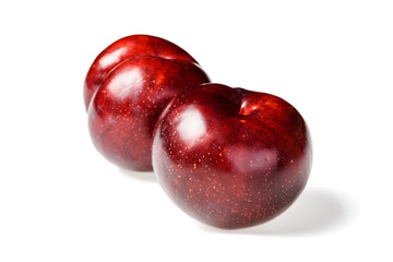 fresh red plums on white