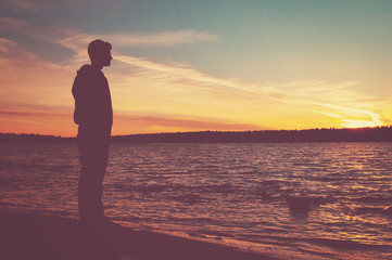 hazy silhouette of a man watching the sunset over Lake Superior at Agawa Bay