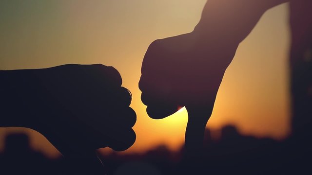 Slow motion of female and male hands showing a thumb down
