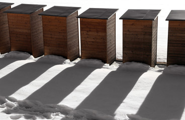Fototapeta na wymiar wooden cabins lined with long shadows in the resort