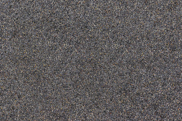 Close up of black sand texture with coloured flecks
