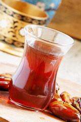Black tea in traditional Islamic cups with sweet dates, selectiv
