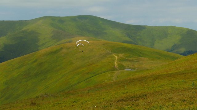 4k,
Paraglider flying high in the mountains