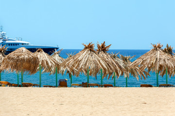 Blue sea, golden sand and sunbeds on the beach