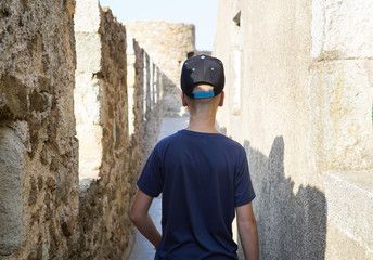 Boy walking on the old stone wall