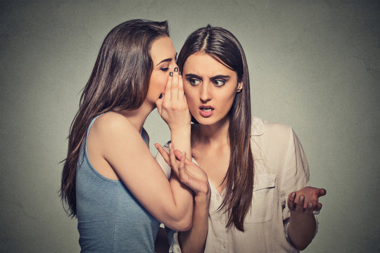 Girl Whispering Into Woman Ear Telling Her Shocking Secret